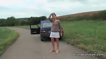 A Charming Young Woman Entices An Elderly Man During A Roadside Encounter